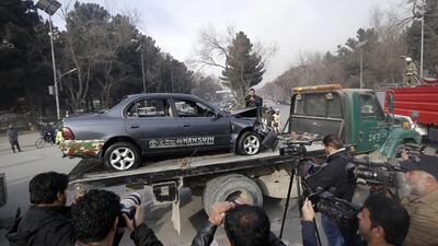 Afghan security officials remove a damaged vehicle from the scene of the suicide bomb attack in Kabul. Hedayatullah Amid / EPA