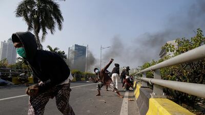 Indonesian protesters throw stones during a clash with police in Jakarta, Indonesia. EPA