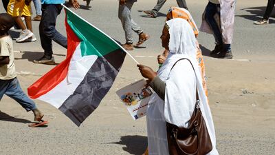 A Sudanese woman carries a flag during the demonstration. Reuters