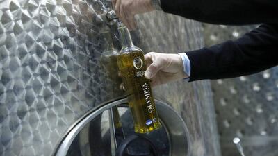 A bottle gets filled from a vat containing extra virgin olive oil at a storage site near Pyrgos in southern Greece. Greece is the world’s third-biggest olive oil producer but has been losing ground to leaders Spain and Italy. Petros Giannakouris / AP Photo