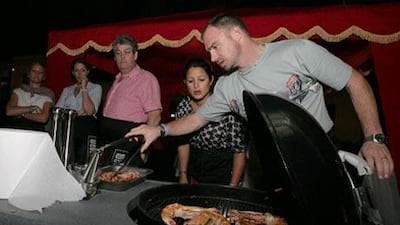 Prawns go on to the heat in the barbecue cooking class at L'Atelier des Ches in Le Meridien Hotel, Dubai. When the cover goes down, it becomes a barbecue; until then it is just a grill.