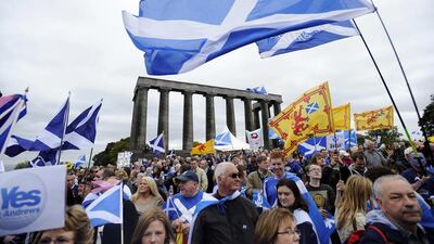Pro-independence supporters wave the Saltire as they gather in Edinburgh for a march and rally in support of a Scottish independence referendum to be held in September. AFP / September 21, 2013