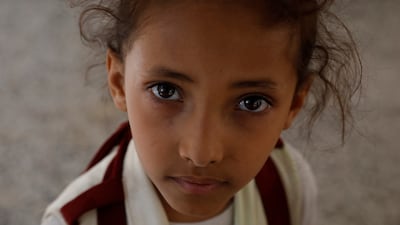 A child waits for humanitarian food aid in Sanaa. Thousands of Yemeni children are at risk of starvation, Unicef has warned. EPA