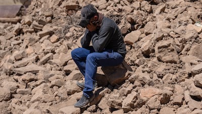 A Moroccan man is overcome with grief as the body of his brother is removed from beneath a collapsed house in Douzrou. Getty Images