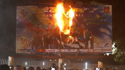 A poster featuring Myanmar's football team burns in Yangon as fans rioted following a tournament-ending loss to Indonesia at the Southeast Asian Games on Monday night. Lynn Bo Bo / EPA