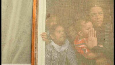 Room with a view: a Palestinian family look from their window at the funeral of Mohammed Makawi in Rafah in the southern Gaza Strip. Ahmed Zakot / Reuters