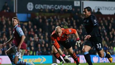 Manchester City's Carlos Tevez breaks past Brad Guzan to score against Aston Villa.