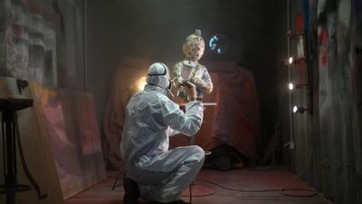 A man varnishes artwork, representing the character of Tintin, by artist Christophe Tixier – alias "Peppone" – in La Roque d'Antheron, southern France. AFP