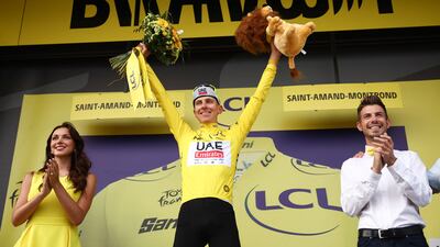 UAE Team Emirates' Slovenian rider Tadej Pogacar celebrates on the podium with the overall leader's yellow jersey. AFP