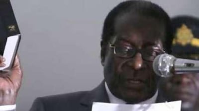 The Zimbabwean president, Robert Mugabe, holds up the bible as he speaks at his inauguration ceremony at State House in Harare.