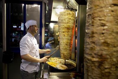 A shawarma cook cuts fresh slices of chicken shawarma at Al Safadi Lebanese restaurant. Silvia Razgova for The National