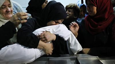 The mother of eight-month-old Leila Anwar Ghandoor, who died in the hospital on Tuesday morning from tear gas inhalation, hugs her daughter a last time as she is prepared for burial on May 15, 2018 in Gaza City, Gaza. Spencer Platt / Getty