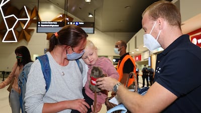 A West Australian Tourism representative offers a young passenger a toy Quokka on arrival at Perth International Airport Terminal. Photo by Paul Kane / Getty Images
