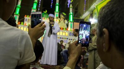 People take videos for a man singing Islamic songs during celebrations two days ahead of the holy month of Ramadan at al-Baragel, Cairo, Egypt. EPA