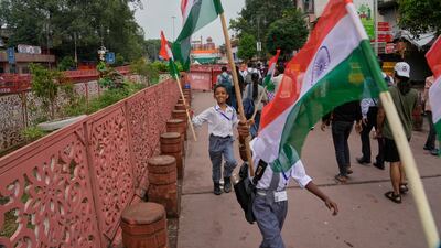 Indian schoolchildren carry their national flags on the eve of Independence Day at the Red Fort in New Delhi, where Prime Minister Narendra Modi is scheduled to address the nation on July 15. AP