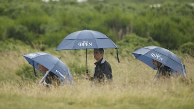 Spectators shelter from the rain under umbrellas during the second round - Royal Troon, Scotland, Britain - 15/07/2016. REUTERS/Paul Childs