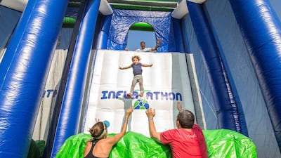 A mother and father cheer their daughter on for the jump at the final course at the Inflatathon obstacles course at Safa Park, Dubai. Leslie Pableo for The National