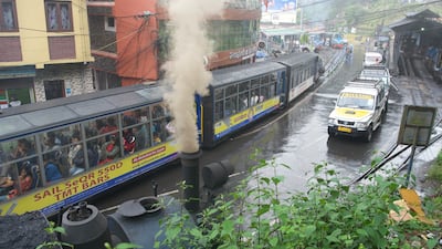 A steam engine alongside modern cars in Darjeeling