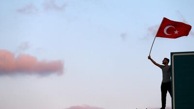 A man waves a Turkey's national flag as he attends a ceremony marking the first anniversary of the attempted coup at the Bosphorus Bridge in Istanbul, Turkey. Reuters