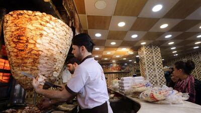 Syrian men prepare shawarma sandwiches at a restaurant in the capital Damascus on December 10, 2015. More than four years into a grinding civil war, the Syrian government is scraping the barrel to boost its revenues with everything from taxes on shawarma sandwiches to telephone lines. Louai Beshara/AFP Photo