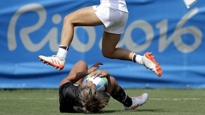 France's Pauline Biscarat, top, jumps over New Zealand's Huriana Manuel, after she scored a try during the women's rugby sevens match at the Summer Olympics in Rio de Janeiro, Brazil, Sunday, Aug. 7, 2016. (AP Photo/Themba Hadebe)
