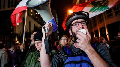 A Lebanese protester speaks in a megaphone as others gather along near the home of caretaker prime minister Saad Hariri. AFP