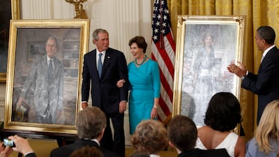 Former US president Barack Obama applauds former president George W Bush and his wife lady Laura Bush during a ceremony in the East Room of the White House in Washington, 2012, where the Bush portraits were unveiled. AP