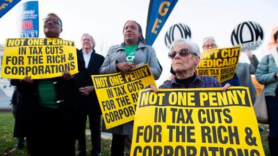 Demonstrators against the US tax reform bill hold a protest rally in Washington, DC. Now that the bill has been passed, it may have effects on growth and monetary policy. Saul Loeb / AFP