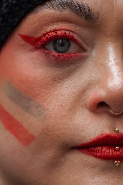 A woman wearing makeup and face paint in the colours of the Iranian flag looks on during a 'Freedom for Iran' protest in New York on March 1, 2026. EPA