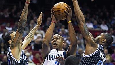 The Mavericks' Dirk Nowitzki, centre, gets through the Orlando defence for a shot on his way to scoring 23 points.