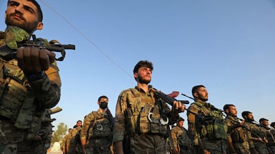 Members of an SDF brigade at a funeral for three Kurdish fighters killed in Aleppo, Syria. AFP
