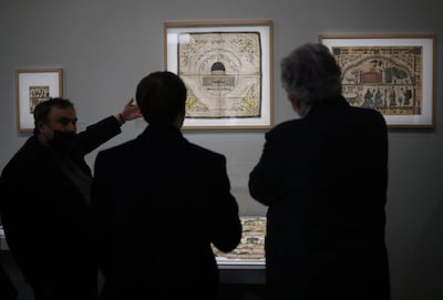 French President Emmanuel Macron, back, and French historian Benjamin Stora, left, visit the exhibition. AFP
