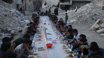 Syrian residents gather at sunset to share the iftar meal amidst the rubble of a destroyed neighbourhood in Atareb town in the rebel-held western countryside of Syria's Aleppo province. AFP