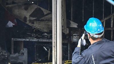 Investigators work inside the building. Kyodo News via AP