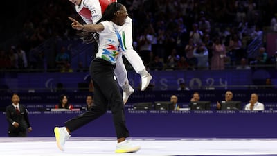 Zakia Khudadadi, top, celebrates becoming the first athlete to win a medal for the Paralympic Refugee Team. AP