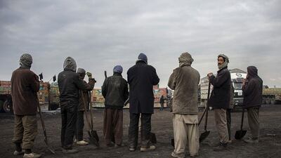 Afghan workers hold shovels as they wait to load coal from Samangan province onto trucks to be transported to Pakistan.