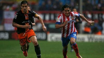 Valencia's Roberto Costa races Radamel Falcao of Atletico Madrid to the ball.