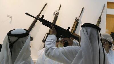 Emirati men look at weapons during the first day of ADIHEX. Karim Sahib / AFP Photo