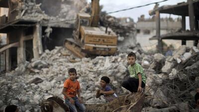 Palestinian children stand in the rubble of destroyed homes and buildings from the 50-day conflict between Hamas and Israel, in Gaza. Mahmud Hams / AFP