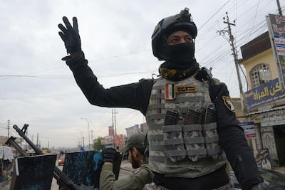 A member of the Iraqi security forces salutes onlookers as he parades in the streets of Mosul. AFP