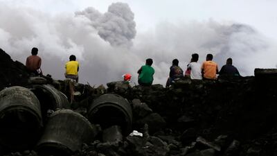 Filipino villagers sit along the slopes of rumbling Mayon Volcano as it spews ash in Legaspi city, Philippines. Francis R. Malasig / EPA