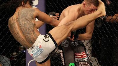 UFC lightweight champion Benson Henderson lands a kick to Nate Diaz.