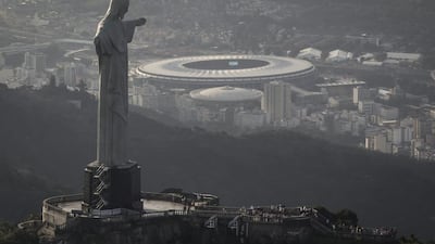 In this May 13, 2014, photo, an aerial view shot through an airplane window shows the Maracana stadium behind the Christ the Redeemer statue in Rio de Janeiro, Brazil. Felipe Dana / AP