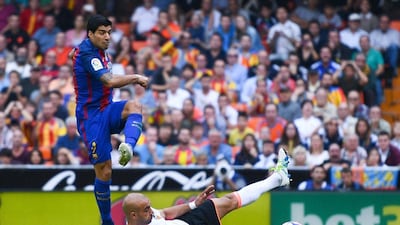 Luis Suarez of FC Barcelona scores his team’s second goal past Aymen Abdennour of Valencia. David Ramos / Getty Images
