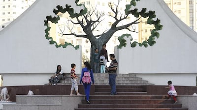 Watch this space: families walk up steps leading to a rolla, or banyan tree, at the redeveloped park in Sharjah. Sarah Dea / The National