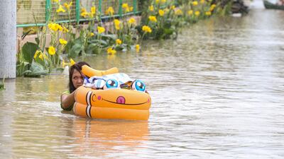 A woman wades through floodwaters in Calumpit, Bulacan province, after Typhoon Doksuri lashed the Philippines. AFP