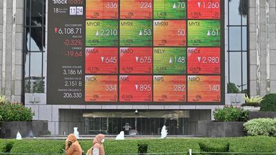 Pedestrians walk past a giant screen showing stock trading information in Jakarta. Indonesia has produced more tech “unicorns” than any other Southeast Asian country. AFP