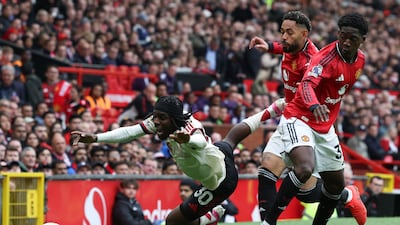 Manchester United's Kobbie Mainoo and Matheus Cunha vie for the ball with Liverpool's Jeremie Frimpong. AFP