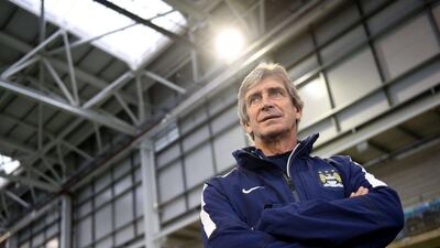 Manchester City's then manager Manuel Pellegrini observes youth footballers during the launch of the new City Football Academy on Monday. AFP
