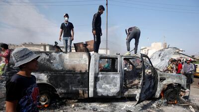 Protesters step on a military vehicle of Iraqi security forces after burning it, during ongoing anti-government protests in Basra, Iraq. Reuters